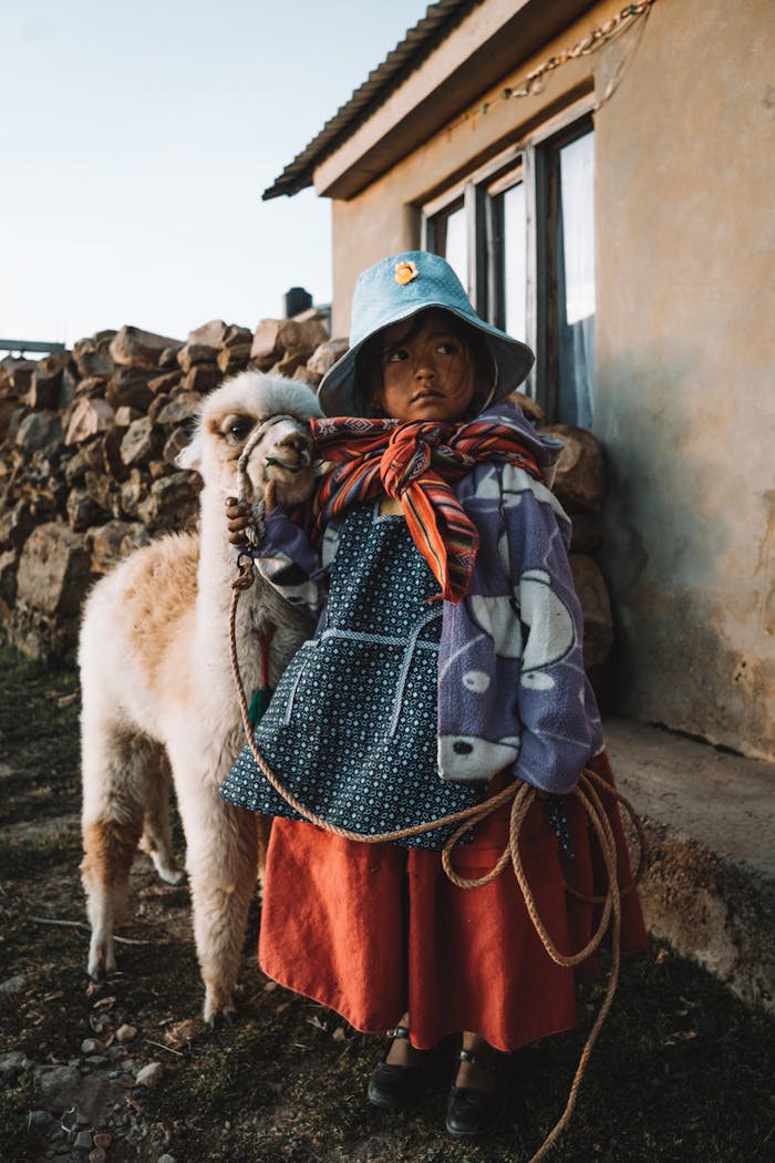 Mastering the First Impression: Your intriguing post title goes here Young girl in traditional clothing with a llama, captured outdoors in a rural setting.